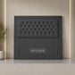 A dark gray upholstered headboard with a tufted button design