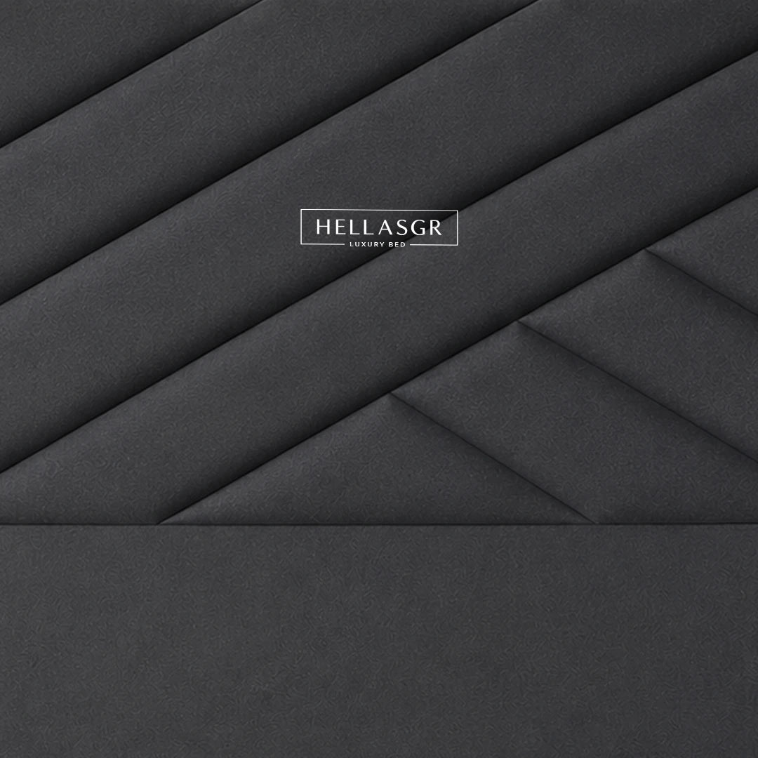 A dark gray upholstered headboard with a geometric diamond quilted pattern 