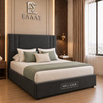 A dark gray upholstered bed frame with a tall padded headboard and matching footboard, styled in a modern bedroom. The bed is dressed in white and sage green bedding, with the brand name 'HELLASGR' visible on the footboard and wall.