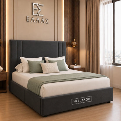 A dark gray upholstered bed frame with a tall padded headboard and matching footboard, styled in a modern bedroom. The bed is dressed in white and sage green bedding, with the brand name 'HELLASGR' visible on the footboard and wall.