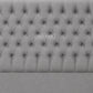 A light gray tufted upholstered headboard