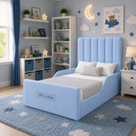 A light blue upholstered children's bed with a tall channel-tufted headboard and matching footboard