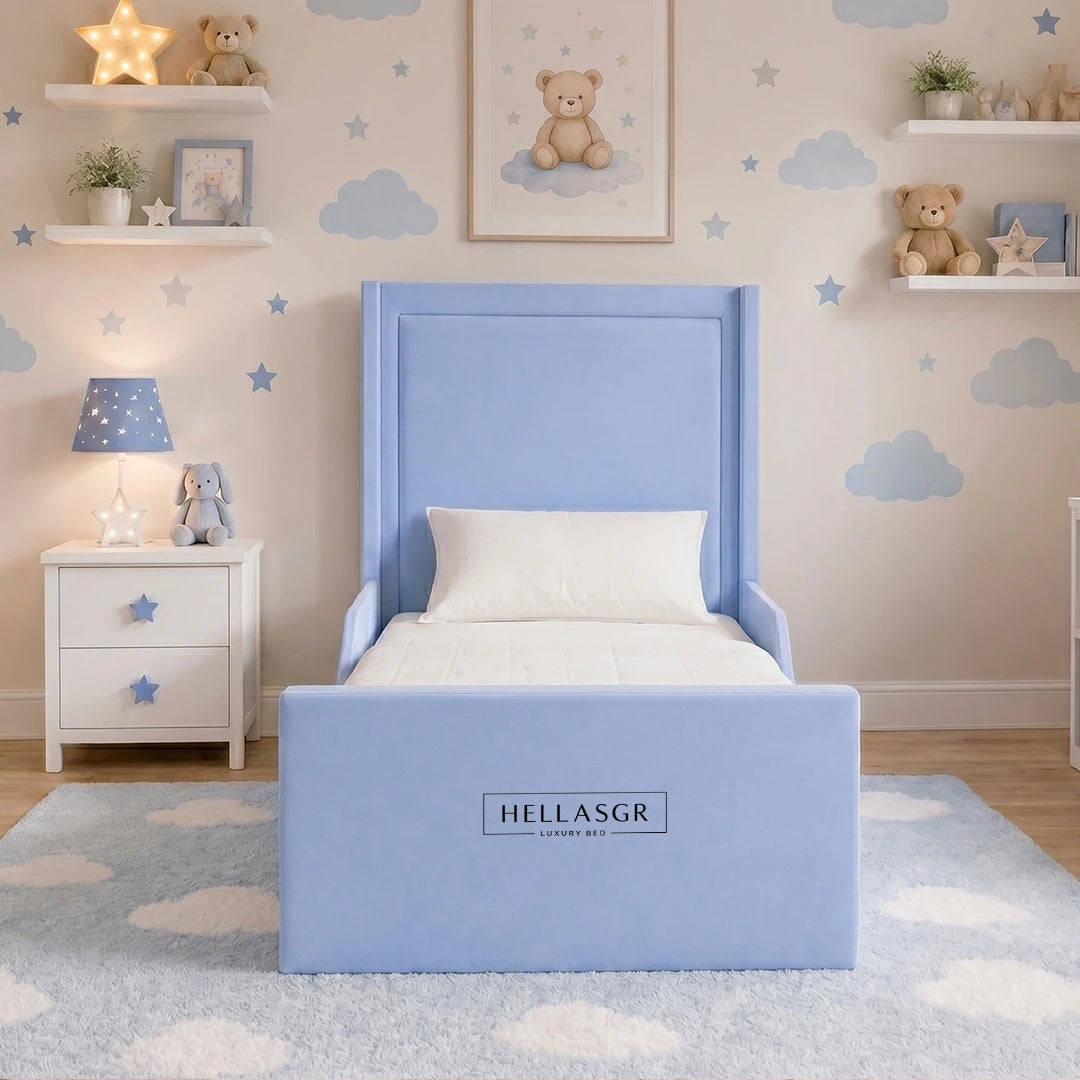 A blue children's bed with a high upholstered headboard and footboard