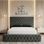 Gray tufted Nera Plush Ottoman bed with white bedding in a bedroom setting, featuring a brand logo on the wall.