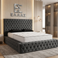 Modern bedroom with a tufted gray Nera Plush Ottoman bed and decorative wall logo.