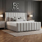 Gray upholstered Newyork Wingback bed in a bedroom with dark panel walls and a logo on the wall.
