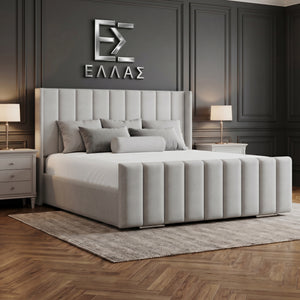Gray upholstered Newyork Wingback bed in a bedroom with dark panel walls and a logo on the wall.