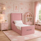 A pink children's bed with a high upholstered headboard and footboard