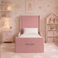 A pink children's bed with a high upholstered headboard and footboard