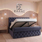 Blue tufted Prisma Royal bed with white mattress in a bedroom setting, featuring a decorative wall with 'ΕΛΛΑΣ' text.