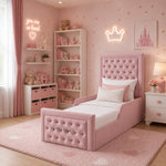 A pink upholstered single bed with a padded headboard and footboard